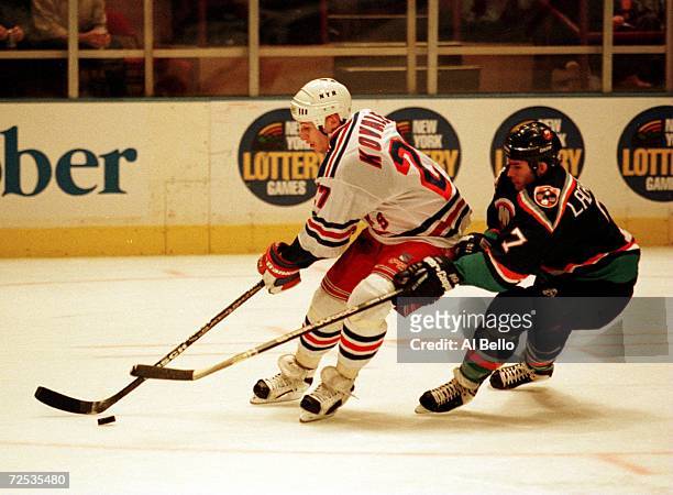 Alexei Kovalev of the New York Rangers shakes off Scott Lachance of the New York Islanders at Madison Square Garden, New York. The Islanders won the...