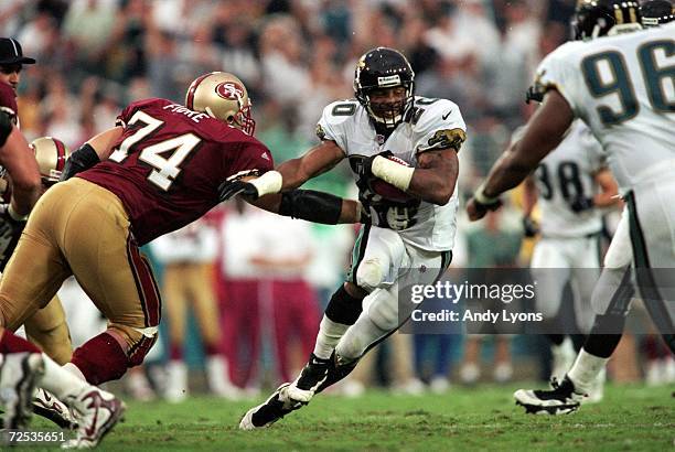 Donovin Darius of the Jacksonville Jaguars moves with the ball away from Dave Fiore of the San Francisco 49ers during the game at the Alltell Stadium...