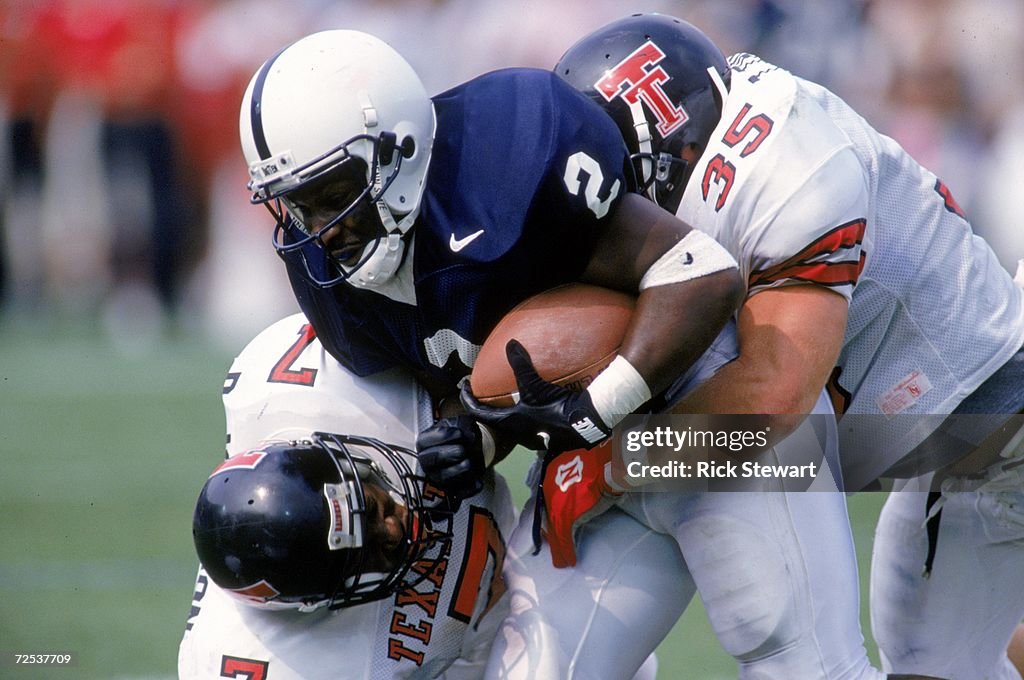 Mike Archie of the Penn St. Nittany Lions carries the ball as he is ...