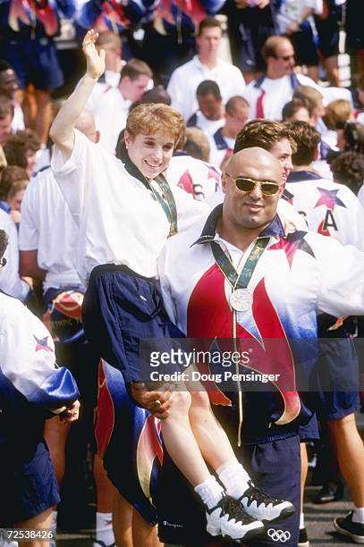 Gymnast Kerri Strug, left, is held up by wrestler Matt Ghaffari of the USA during a ceremony with President Bill Clinton for all U.S. Olympic...