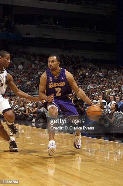 Point guard Derek Fisher of the Los Angeles Lakers drives past point guard Antonio Daniels of the San Antonio Spurs during the NBA game at the...