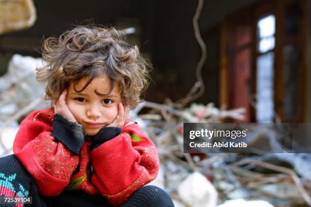 Palestinian girl sits on the rubble of her destroyed home January 16, 2003 in the Rafah Refugee Camp, in southern Gaza Strip. Israeli troops...