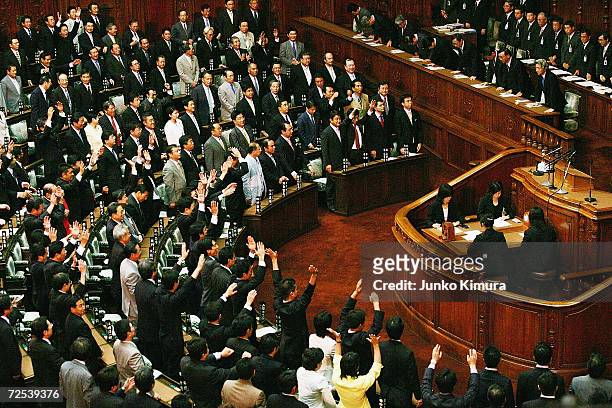 Japanese Prime Minister Junichiro Koizumi bows as other House of Representative members shouts "Banzai" during the plenary session on August 8, 2005...