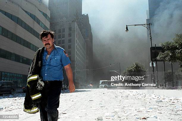 An unidentified New York City firefighter walks away from Ground Zero after the collapse of the Twin Towers September 11, 2001 in New York City. The...