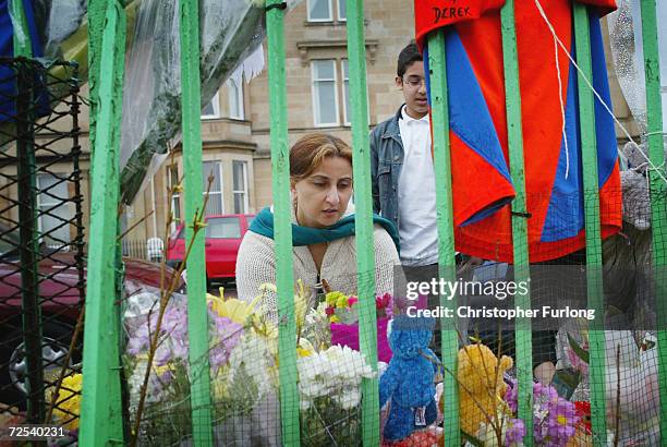 Local resident places flowers amongst the tributes that mark the scene, March 18, 2004 where 15-year-old Kriss Donald was abducted by a gang of five...