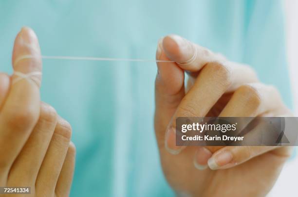 close up of woman's hands with dental floss - zahnseide stock-fotos und bilder