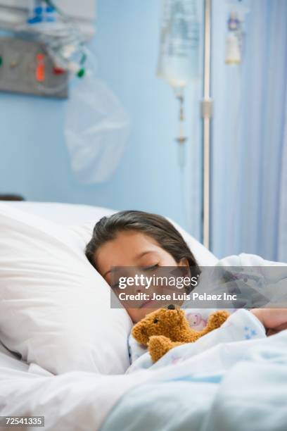 young girl sleeping in hospital bed - teddy bear stock pictures, royalty-free photos & images