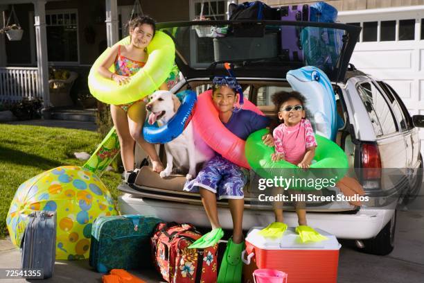 children in beach gear sitting in back of packed car - feeling full stock pictures, royalty-free photos & images