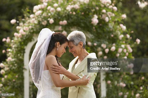 hispanic bride and mother touching foreheads - mother congratulating stock pictures, royalty-free photos & images