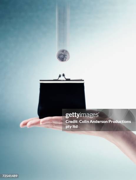 coin falling into change purse in woman's hand - miserly stock pictures, royalty-free photos & images