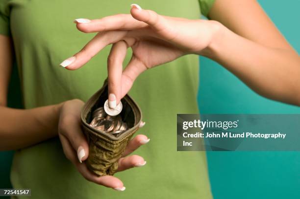 close up of woman taking coin out of change purse - posizionare foto e immagini stock