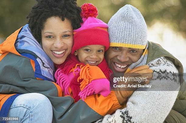 african family wearing winter clothes and hugging - ariel winter hot stock pictures, royalty-free photos & images