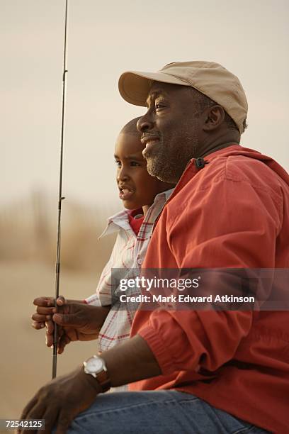 african father and son on beach with fishing gear - african american man day dreaming stock pictures, royalty-free photos & images