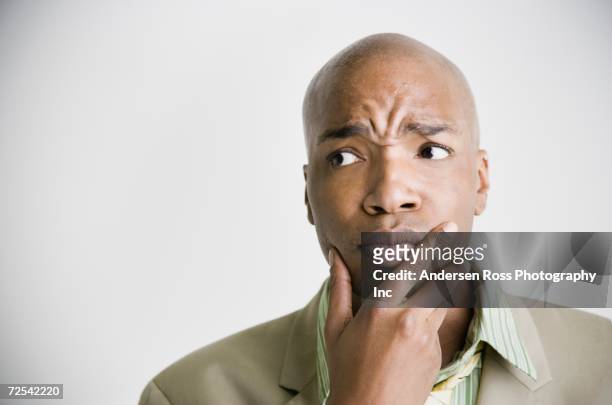 african businessman with hand on chin - thinking facial expression stock pictures, royalty-free photos & images