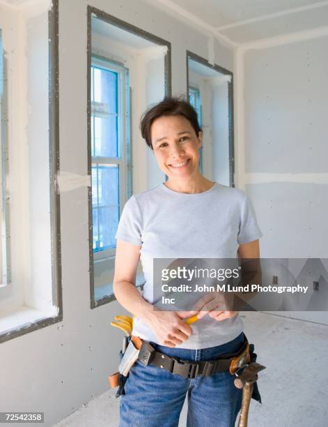 woman wearing tool belt and smiling - cintura per gli attrezzi foto e immagini stock