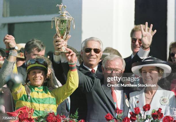 Jockey Chris Antley, trainer D. Wayne Lukas, owners Robert and Beverly Lewis hoist the winners'' trophy atfter Charismatic captured the 125th...