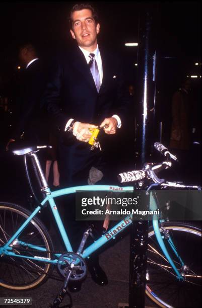 John F. Kennedy, Jr. Locks up his bike at a sign post December, 1997 in New York City. July 16, 2000 marks the one year anniversary that John F....