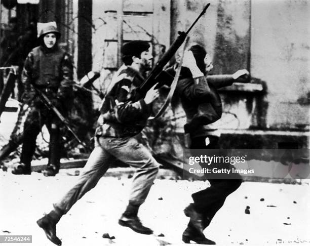 British paratrooper takes a captured youth from the crowd on "Bloody Sunday," when British paratroopers opened fire on a civil rights march, killing...