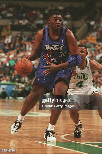 Oliver Miller of the Toronto Raptors dribbles the ball down court, pursued by David Wesley of the Boston Celtics, during the Raptors 136-108 loss to...