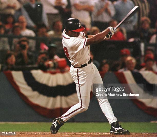Jermaine Dye of the Atlanta Braves hits a sacrifice fly to score Fred McGriff in the first inning of game 6 of the National League Championship...