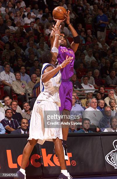 Vince Carter of the Toronto Raptors shoots the ball while defended by Tracy McGrady of the Orlando Magic during their NBA opening night game at the...