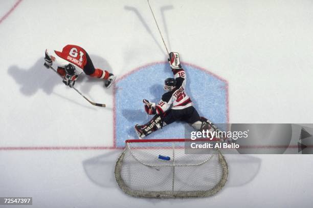 Chris Terreri of the New Jersey Devils stetches out to block the puck as Mikael Renberg of the Philadelphia Flyers shoots at the Continental Airlines...