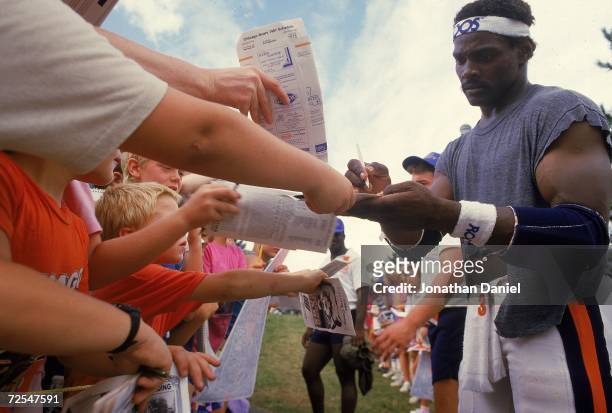 Walter Payton of the Chicago Bears signs autographs during training camp.
