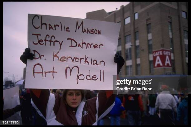 Fans hold various signs which accuse Cleveland Browns owner Art Modell of disregard of fans which compares him to famous murderers at Cleveland...