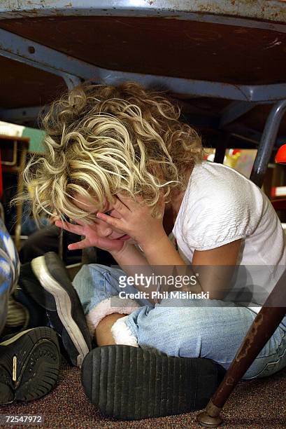 Kindergarten student hides under her desk during a classroom lockdown drill February 18, 2003 in Oahu, Hawaii. Lockdown procedure is used to protect...