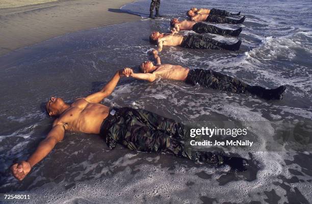 Navy Seal trainees lie in the frigid Pacific surf in this undated photo taken in 2000 at the Coronado Naval Amphibious Base in San Diego, California....