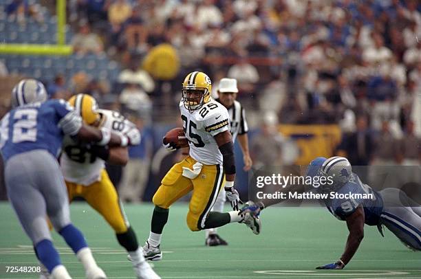 Runningback Dorsey Levins of the Green Bay Packers runs around Robert Porcher of the Detroit Lions during a game at the Pontiac Silverdome in...