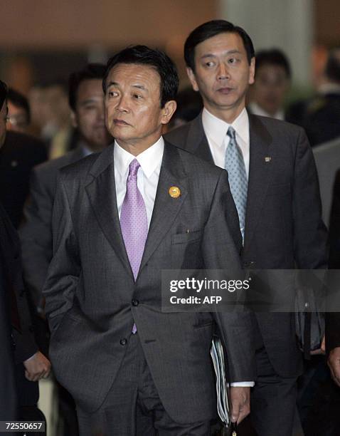 Japan's Foreign Minister Taro Aso and an aide arrive for the Asia-Pacific Economic Cooperation Summit in Hanoi 15 November 2006. WTO Chief Pascal...
