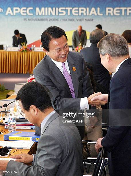 Japanese Foreign Minister Taro Aso greets other attendants prior to the Asia Pacific Economic Cooperation Ministerial Meeting Retreat in Hanoi, 15...