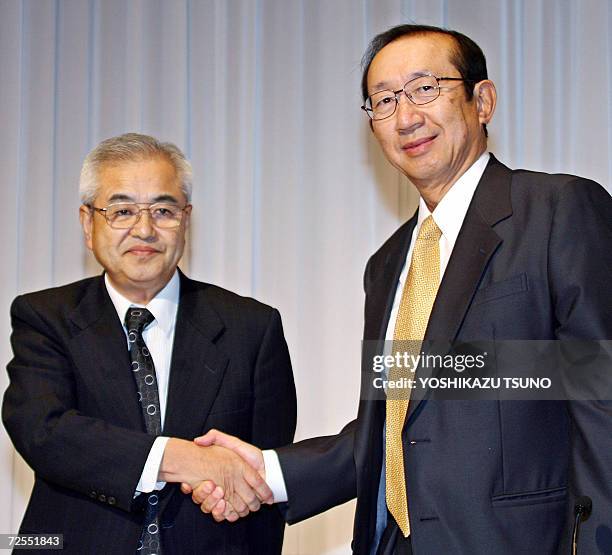 Japan's Nissin Food Products President Koki Ando shakes hands with Myojo Foods Prresident Hironobu Nagano as they announce Nissin, inventor of...