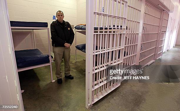 Buffalo, UNITED STATES: Dallas County Sheriff Mike Rackley stands in the holding cell 14 November 2006 of his newly painted county jail with the...