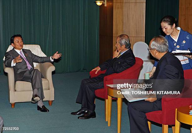 Japanese Foreign Minister Taro Aso chats with Japan's ABAC representatives, Yoshio Ishizaka and Yasuo Kanzaki prior to start their talks at a hotel...