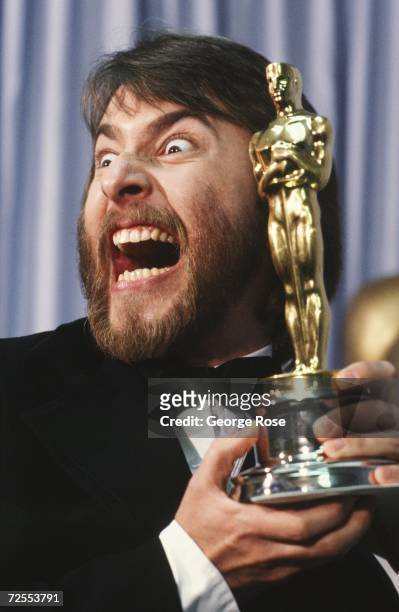 Academy Award-winning makeup artist, Rick Baker, poses in a 1981 Los Angeles, California, backstage photo shoot with his Oscar. Baker won the award...