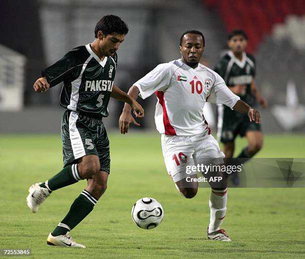 Abu Dhabi, UNITED ARAB EMIRATES: Emirati player Ismail Matar vies with Pakistan's Ishaq Samar during their qualifying football match for the 2007...