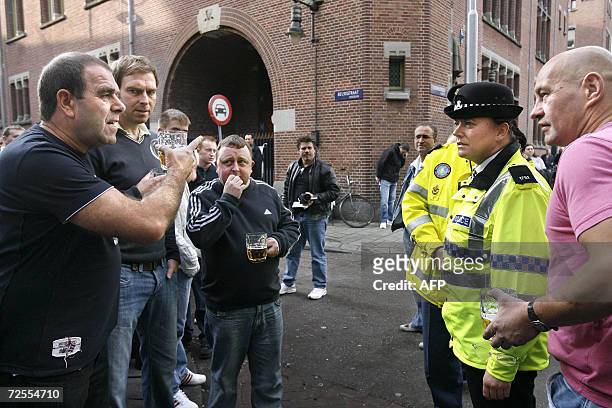 Amsterdam, NETHERLANDS: British policemen talk to England soccer fans in Amsterdam, 15 November 2006 ahead of the friendly football match England vs....