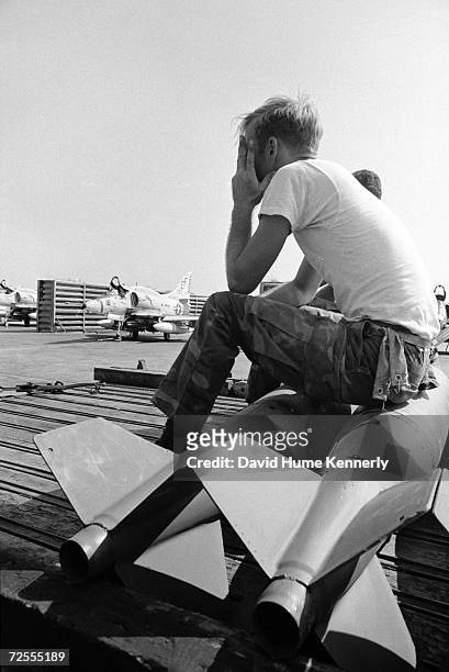 Marine rests on a pair of bombs in 1973 at an airbase in Bien Hoa, Vietnam.