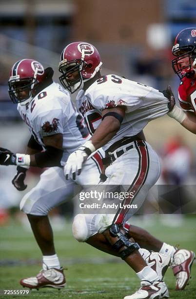 Defensive end John Abraham of the South Carolina Gamecocks has his jersey held by a player from the Mississippi Rebels during a game at the...