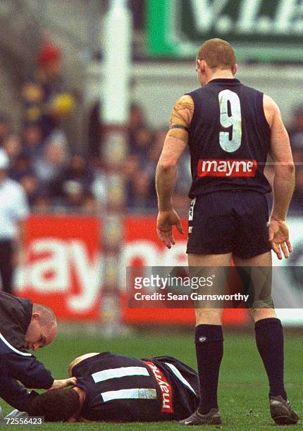 Adrian Hickmott for Carlton looks over his injured team mate Mark Porter for Carlton, in the round 22 AFL match between the Carlton Blues and the...