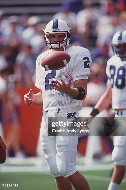 Quarterback Tim Couch of the Kentucky Wildcats stares into the backfield as he turns to hand off the football to his running back during a play in...