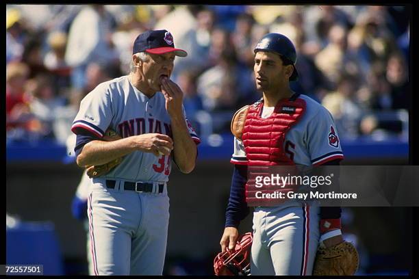 All time great Atlanta Braves pitcher Phil Niekro, now a coach of the Cleveland Indians, talks with catcher Chris Bando of the Indians. Mandatory...