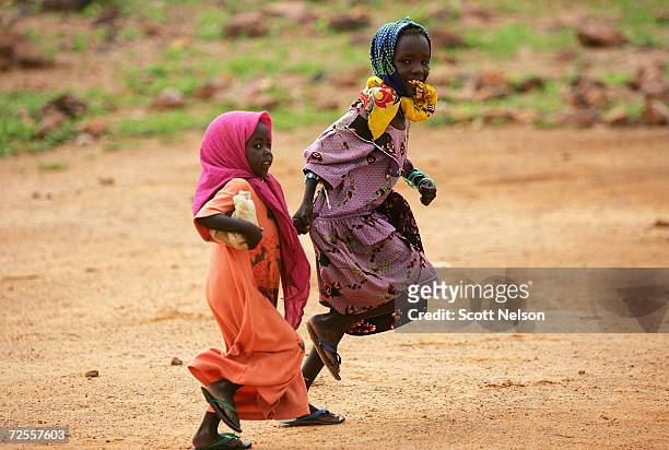 Sudanese refugee girls from the Darfur region of Sudan run home after attending a UNICEF school in the Farshana refugee camp August 29, 2004 in...
