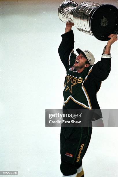 Mike Modano of the Dallas Stars carries the Stanley Cup on the ice after the Stanley Cup game against the Buffalo Sabres at the Marine Midland Arena...