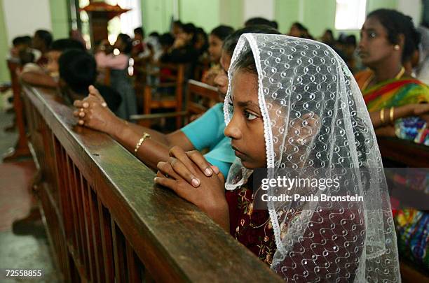 Sri Lankans pray during Sunday mass at St. Mary's catholic church January 9, 2004 in Batticaloa, Sri Lanka. An estimated 150,000 were killed in the...