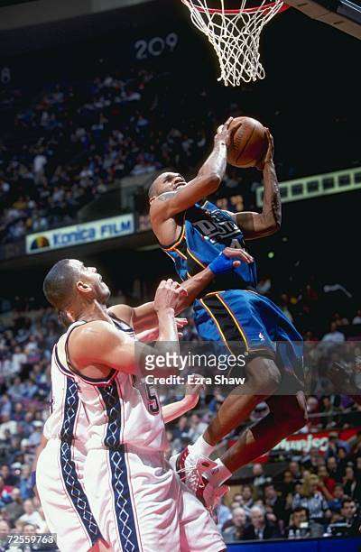 Jerry Stackhouse of the Detroit Pistons jumps to make the basket during a game against the New Jersey Nets at the Continental Airlines Arena in East...