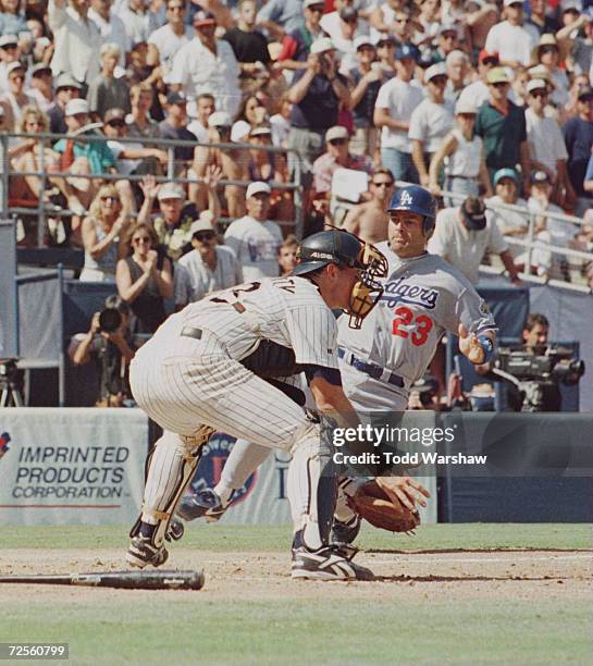 First baseman Eric Karros of the Los Angeles Dodgers focuses in on home plate as he begins his attempted slide past catcher John Flaherty of the San...