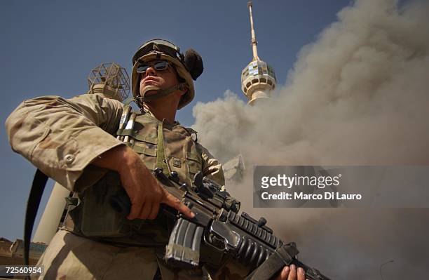 Army soldier stands by the burning Saddam Communication Tower Complex May 24, 2003 in Baghdad, Iraq. This is the third time the complex has been the...